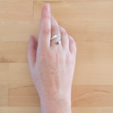 Hand of woman wearing the Amethyst and Sterling Silver Adjustable Ring with One Stone and One Granule