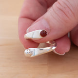 Hand of woman holding the Carnelian and Sterling Silver Adjustable Ring with One Stone and One Granule