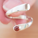 Hand of woman holding the Garnet and Sterling Silver Adjustable Ring with One Stone