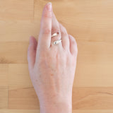 Hand of woman wearing the Garnet and Sterling Silver Adjustable Ring with One Stone