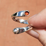 Hand of woman holding the Garnet and Sterling Silver Adjustable Ring with One Stone and One Granule