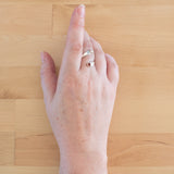 Hand of woman wearing the Garnet and Sterling Silver Adjustable Ring with One Stone and One Granule