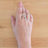 Hand of woman wearing the Hematite and Sterling Silver Adjustable Ring with One Stone and One Granule