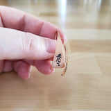 Woman Holding Triangle-Shaped Dangle Earrings in Copper