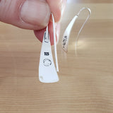 Woman Holding Triangle-Shaped Dangle Earrings in Sterling Silver Stamped with Kokopelli
