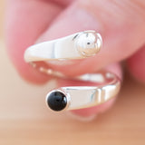 Hand of woman holding the Onyx and Sterling Silver Adjustable Ring with One Stone and One Granule