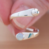 Hand of woman holding the Opal and Sterling Silver Adjustable Ring with One Stone and One Granule