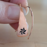 Hand Holding Triangle-Shaped Dangle Earrings in Copper Stamped with Pinwheels
