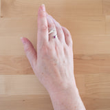 Hand of woman wearing the Ruby and Sterling Silver Adjustable Ring with One Stone and One Granule