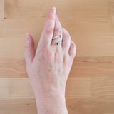 Hand of woman wearing the Ruby and Sterling Silver Adjustable Ring with Two Stones