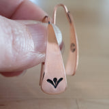 Hand Holding Triangle-Shaped Dangle Earrings in Copper Stamped with Sprouts