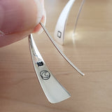 Woman holding Triangle-Shaped Dangle Earrings in Sterling Silver stamped with squares