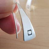 Woman holding Triangle-Shaped Dangle Earrings in Sterling Silver stamped with squares