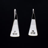 Front view of triangle-shaped sterling silver earrings stamped with triple spiral from Capulin Creations
