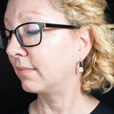 Lifestyle view of triangle-shaped dangle earrings in copper from Capulin Creations