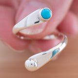Hand of woman holding the Turquoise and Sterling Silver Adjustable Ring with One Stone and One Granule