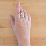 Hand of woman wearing the Turquoise and Sterling Silver Adjustable Ring with One Stone and One Granule