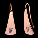 Front and side views of triangle-shaped copper earrings stamped with hot air balloons from Capulin Creations