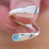 Hand of woman holding the Blue Topaz and Sterling Silver Adjustable Ring with One Stone