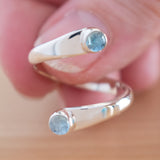 Hand of woman holding the Blue Topaz and Sterling Silver Adjustable Ring with Two Stones