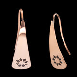 Front and side views of triangle-shaped copper earrings stamped with flowers from Capulin Creations