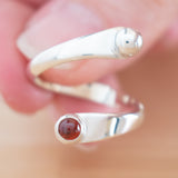 Hand of woman holding the Garnet and Sterling Silver Adjustable Ring with One Stone and One Granule