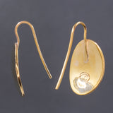 Back and side views of hammered dangle earrings in brass