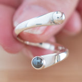 Hand of woman holding the Hematite and Sterling Silver Adjustable Ring with One Stone and One Granule