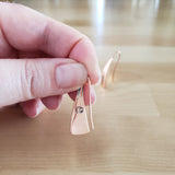 Woman Holding Triangle-Shaped Dangle Earrings in Copper