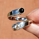 Hand of woman holding the Onyx and Sterling Silver Adjustable Ring with One Stone and One Granule