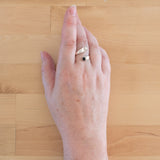 Hand of woman wearing the Onyx and Sterling Silver Adjustable Ring with One Stone and One Granule