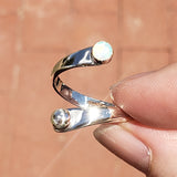 Hand of woman holding the Opal and Sterling Silver Adjustable Ring with One Stone and One Granule