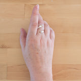 Hand of woman wearing the Opal and Sterling Silver Adjustable Ring with Two Stones