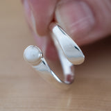 Hand of Woman Holding Pearl and Sterling Silver Adjustable Ring with One Stone