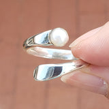 Hand of Woman Holding Pearl and Sterling Silver Adjustable Ring with One Stone