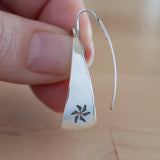 Hand Holding Triangle-Shaped Dangle Earrings in Sterling Silver Stamped with Pinwheels