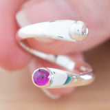 Hand of woman holding the Ruby and Sterling Silver Adjustable Ring with One Stone and One Granule