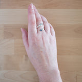 Hand of woman wering the Sapphire and Sterling Silver Adjustable Ring with One Stone and One Granule
