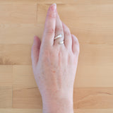 Hand of woman wearing the Sterling Silver Adjustable Ring with One Granule
