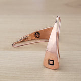 Front and back views of Triangle-Shaped Dangle Earrings in Copper stamped with squares