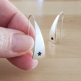 Woman holding Triangle-Shaped Dangle Earrings in Sterling Silver stamped with stars