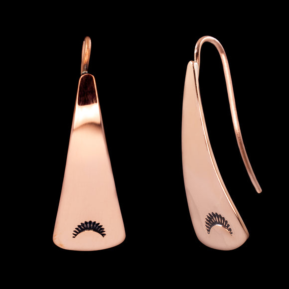 Front and side views of triangle-shaped dangle earrings stamped with sunrays in copper from Capulin Creations