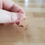 Woman holding Triangle-Shaped Dangle Earrings in Copper Stamped with Sunrays