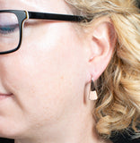 Woman wearing triangle-shaped copper dangle earrings from Capulin Creations