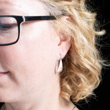 Woman wearing triangle-shaped sterling silver earrings from Capulin Creations