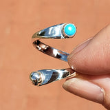 Hand of woman holding the Turquoise and Sterling Silver Adjustable Ring with One Stone and One Granule